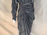 une robe de mannequin posée sur un pied de mannequin devant un fond blanc