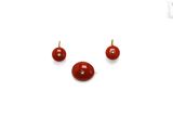two small red beads are sitting next to each other on a white surface