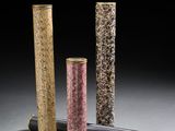 trois tubes de couleurs différentes sont alignés sur une surface grise