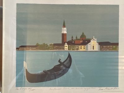 une photo d'une gondole sur l'eau, avec un bâtiment en arrière-plan