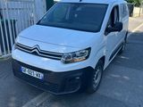 une camionnette blanche garée sur un parking près d'une clôture