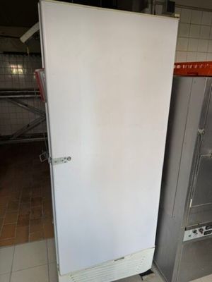 un réfrigérateur blanc dans une cuisine, à côté d'une cuisinière