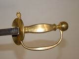 a close up of a gold sword with a black handle