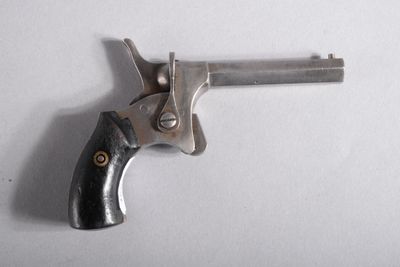 gros plan d'un revolver sur une surface blanche