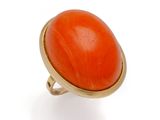 une bague orange, corail et or sur fond blanc