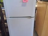 a refrigerator that has a pink sticker on it