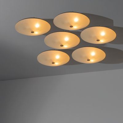 six luminaires dans une pièce aux murs et au plafond blancs
