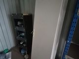 a white refrigerator in the corner of a room next to a shelf