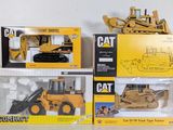 three different models of a cat tractor and a bulldozer