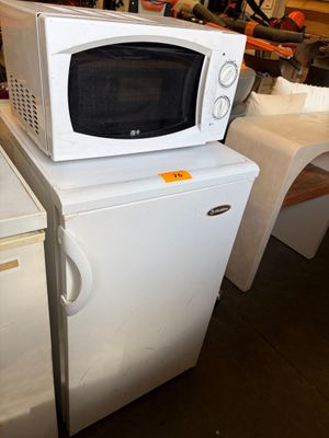 a white microwave sitting on top of a white refrigerator