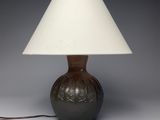 a lamp that is sitting on a table with a white shade on it