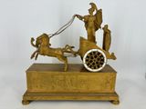 une statue en bronze représentant un homme conduisant une calèche tirée par un cheval