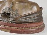 bronze bust of a woman with a flower in her hair