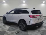 the rear end of a white suv parked on a checkered floor