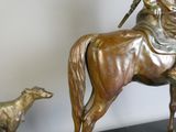 une statue en bronze représentant un homme à cheval et un chien
