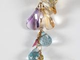necklace with multi colored stones hanging from it ' s gold chain