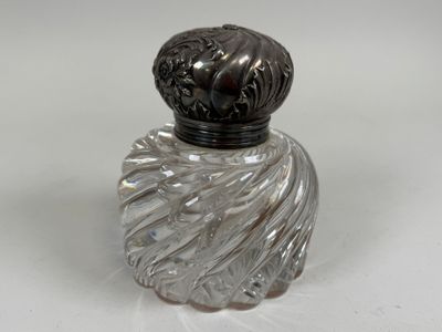 a glass bottle with a black lid on a white surface