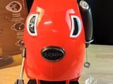 a red coffee maker sitting on top of a wooden table