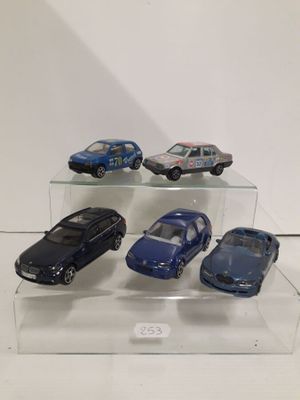 five toy cars on display on a clear shelf