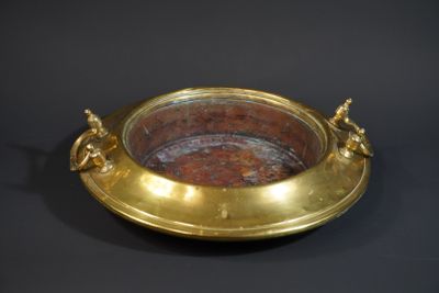 a gold plate with a handle on a black background