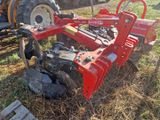 un tracteur immobilisé dans l'herbe, avec une charrue attelée derrière lui