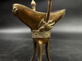 an image of a bronze statue of a bird on a pedestal