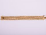 a gold bracelet on a white background