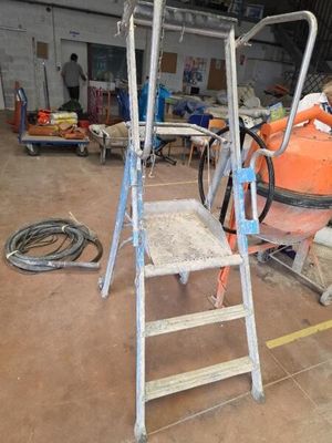 une photo d'une échelle dans un garage, à côté d'autres outils