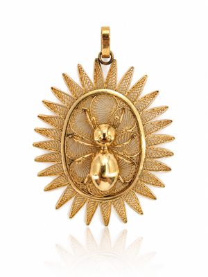 une image représentant un pendentif en or orné d'une abeille