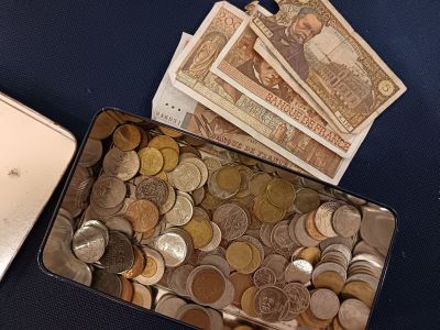 a tin of money sitting next to a laptop computer