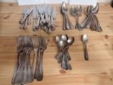 a lot of silver spoons and forks on the table