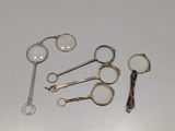 plusieurs paires de ciseaux et une loupe posés sur une table