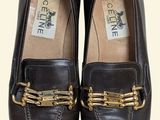 pair of brown loafers with gold chains on them on a white background