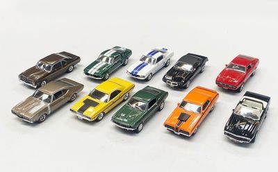 several toy cars are lined up in a row on a white surface