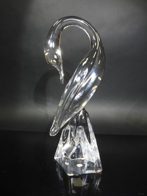 a clear glass swan figurine sitting on top of a black table