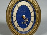 une horloge dorée au cadran bleu posée sur une table