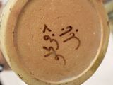 a close up of a vase with a face drawn on it