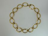 a close up of a gold chain bracelet on a white surface