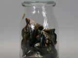 a glass jar filled with nuts on a white surface