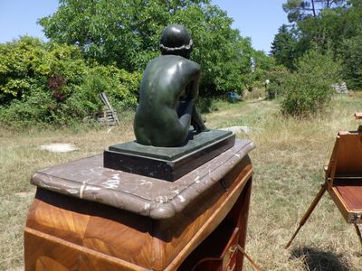 une statue représentant un garçon assis sur un bureau
