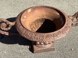 an old rusted vase sitting on the ground