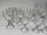a lot of wine glasses and a pitcher on the table