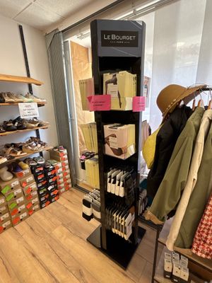 un présentoir de vêtements dans un magasin, surmonté d'un chapeau