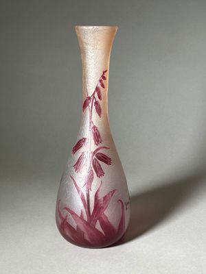un vase en verre orné d'un motif rose et blanc