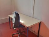 a desk and a chair in a room with a red floor
