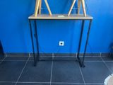 a desk with a lamp on top of it next to a blue wall