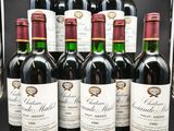 six bouteilles de vin rouge sont alignées dans une vitrine