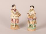 pair of porcelain figurines of a woman holding a child