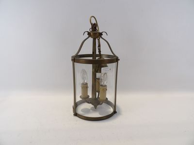une lanterne à l'ancienne, avec deux bougies à l'intérieur, posée sur une surface blanche