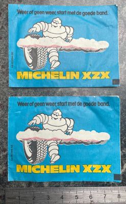 deux autocollants « Michel XXX » posés sur une table, à côté d'une règle